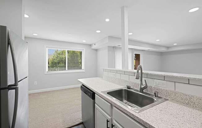 A modern kitchen with a stainless steel sink and refrigerator.