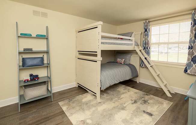 A bedroom with a bunk bed and a ladder.