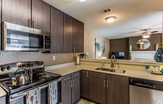 A kitchen with a stove, microwave, and sink.