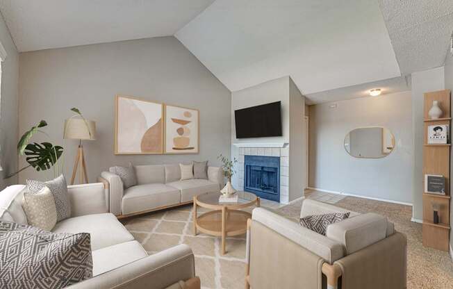 A living room with a fireplace and a TV on the wall.