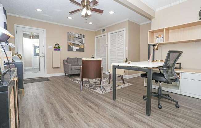 A leasing office with a ceiling fan and a desk with a computer  at The Creole Apartments in Shreveport, LA