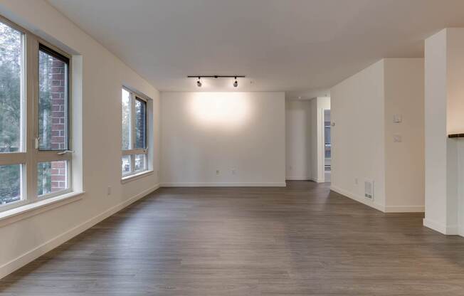 A large empty room with wooden floors and white walls.