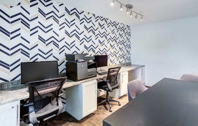 an office with desks and chairs and a wall with a checkered wallpaper