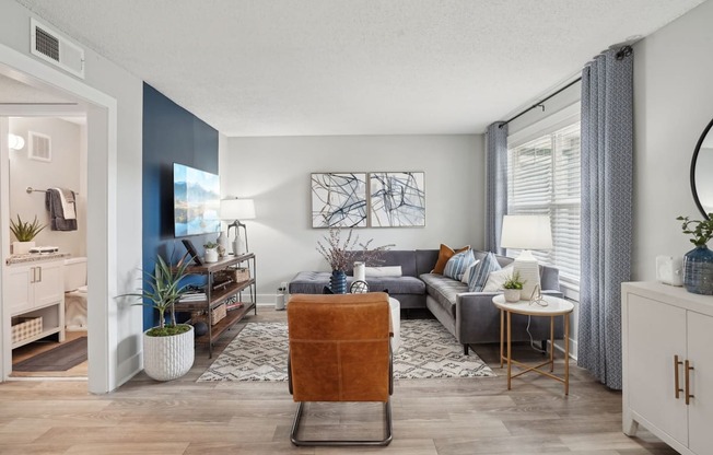 Open-concept living room with natural light and wood-style flooring in a Hendersonville apartment