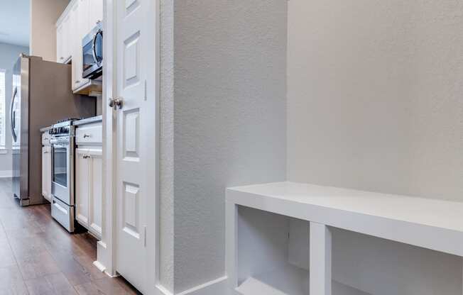 a renovated kitchen with white cabinets and a wood floor