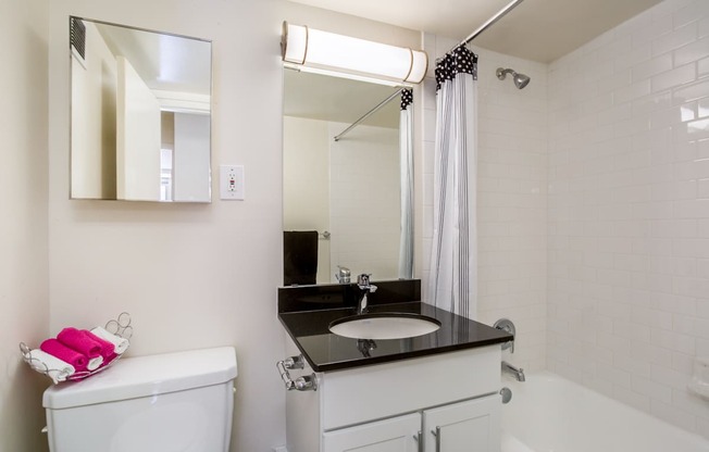 A bathroom with a white toilet, sink, and bathtub.