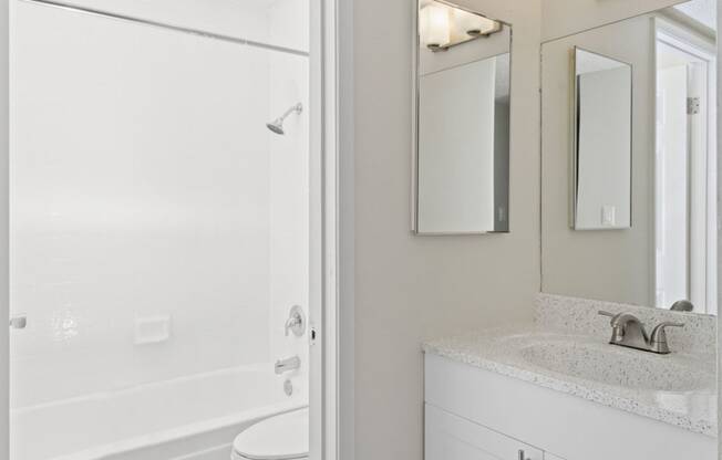 a bathroom with a shower and a sink and a mirror