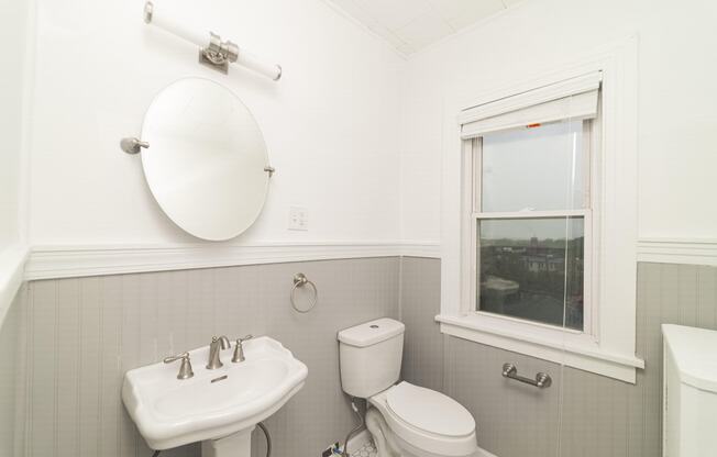 a white bathroom with a sink toilet and a window at The Packard, West Hartford, CT, 06119