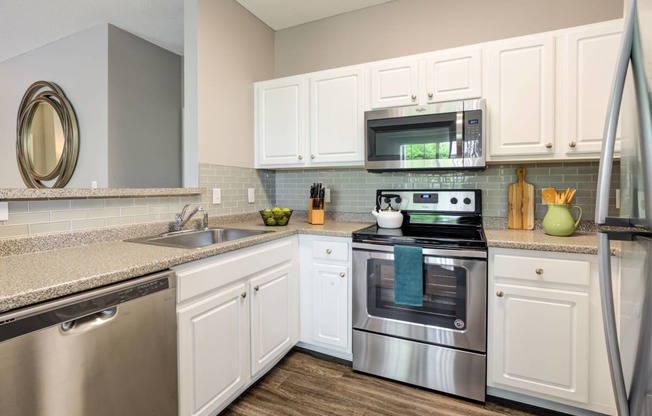 a kitchen with stainless steel appliances and white cabinets