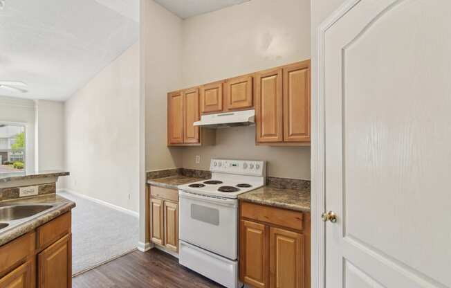 an empty kitchen with wooden cabinets and white appliances