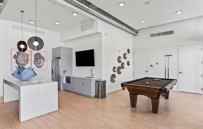 a living room with a pool table and a tv