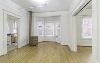 an empty living room with wood floors and a bay window at Clay & Tiffany, Portland, OR, 97201