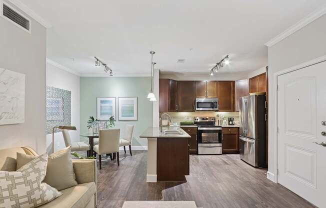 A modern kitchen with dark wood cabinets and stainless steel appliances.