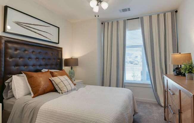 A bedroom with a large bed and a painting above it.