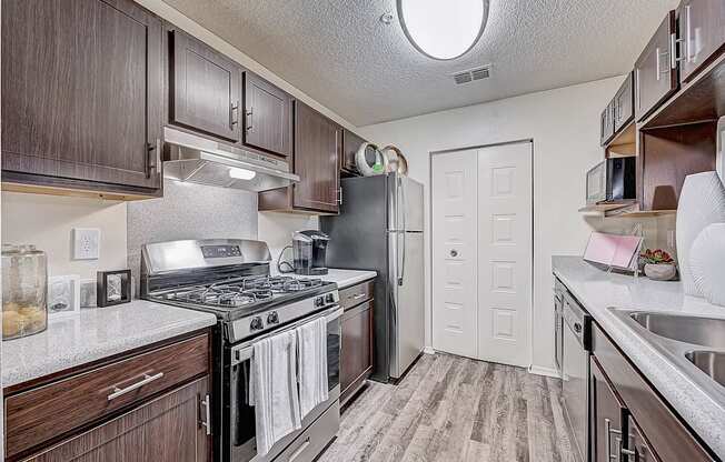 a kitchen with wood cabinets and stainless steel appliances at St. Johns Forest Apartments, Florida, 32277