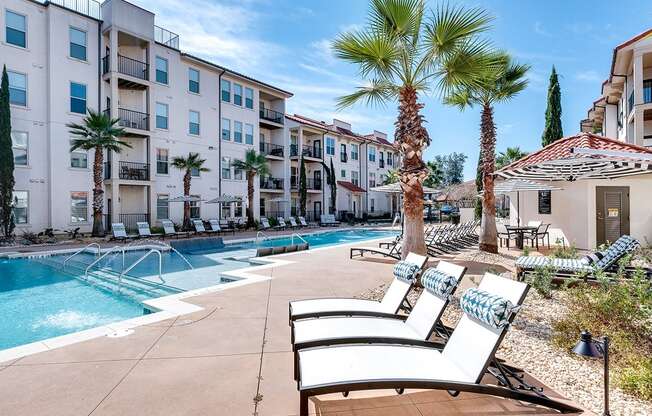 Swimming pool deck with palm trees  at Two Addison Place Apartments , Pooler, GA