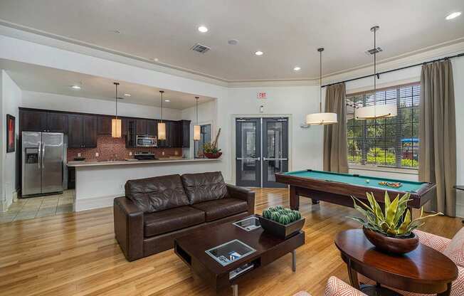 A modern living room with a pool table and a refrigerator.