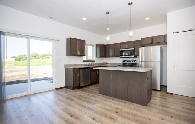 a large kitchen with wooden floors and stainless steel appliances