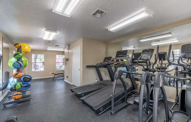 A gym with treadmills, elliptical machines, and other exercise equipment.