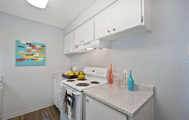 a kitchen with white appliances and a granite counter top