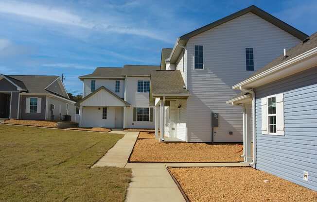 a row of newly built houses, neat sidewalks, and green grass at The Sanctuary at Indian Creek