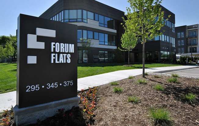 a sign in front of a building that reads forum flats