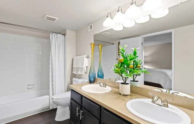 A bathroom with a white tub, sink, and mirror.