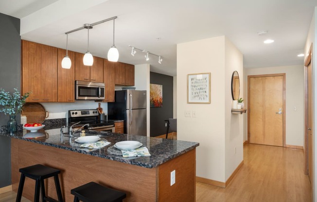 a kitchen with a granite counter top and a stainless steel refrigerator