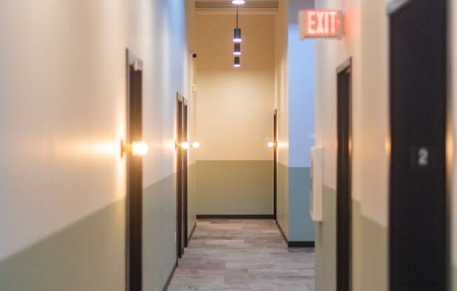 a long corridor with black doors and white walls at The 22 Apartments, St. Louis, MO