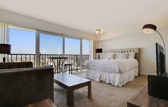 living and sleeping area with carpet floorings, large windows, balcony with spectacular views