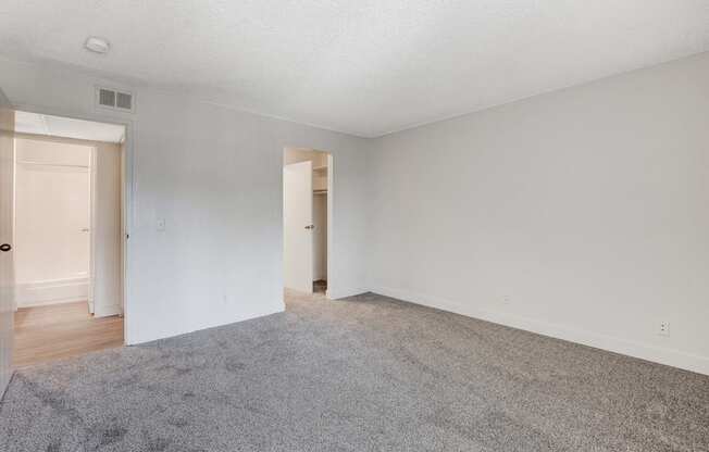 A room with a grey carpet and white walls.
