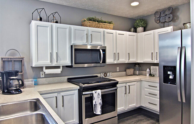 A kitchen with white cabinets and a black stove top.