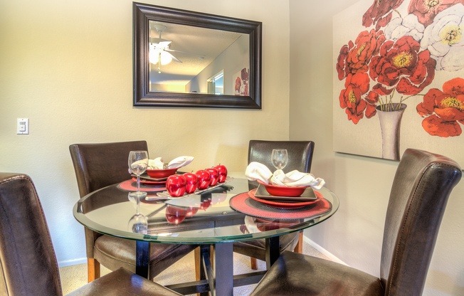 A dining table with chairs and a painting on the wall.