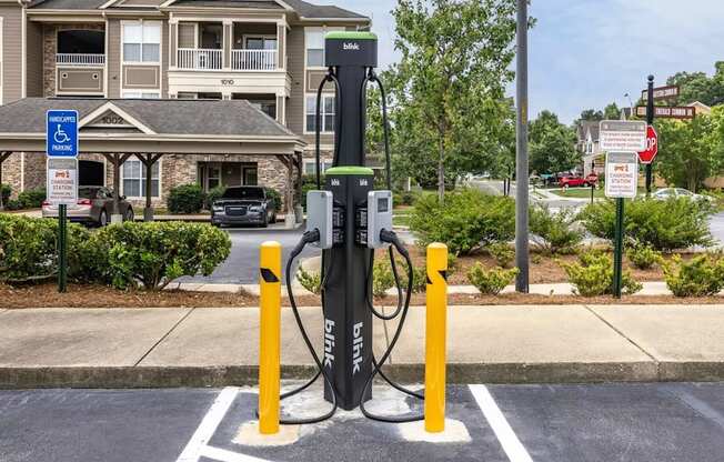 A black electric vehicle charging station sits in a parking spot.