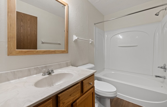 A white bathroom with a sink, toilet, and bathtub.