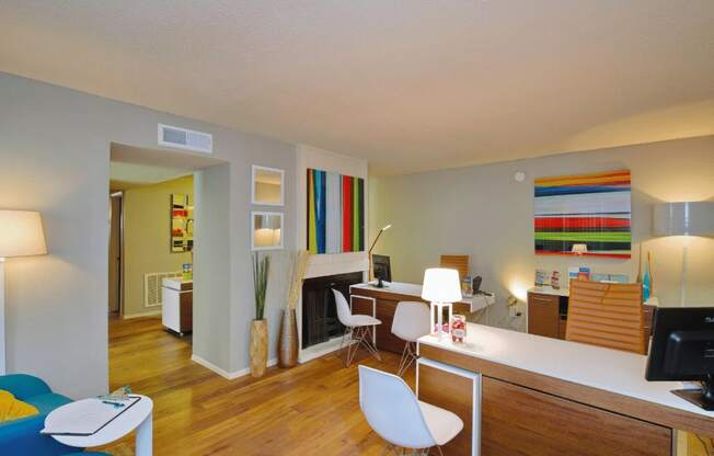 a living room with a desk and a fireplace