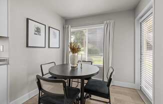 a dining room with a table and chairs and a window