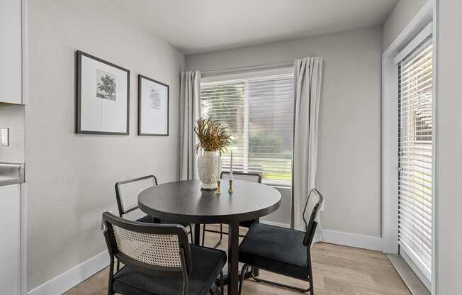 a dining room with a table and chairs and a window