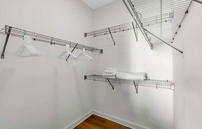 A white laundry room with a clothes drying rack and towel rack.