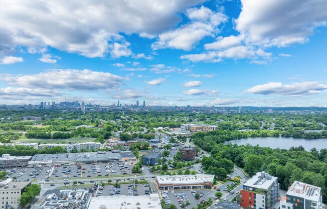A cityscape with a mix of buildings and greenery under a blue sky with clouds at 603 Concord Apartments, Massachusetts