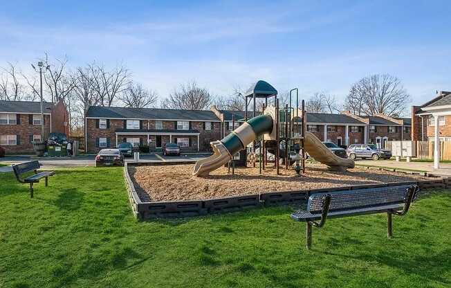 a playground with two slides and a bench