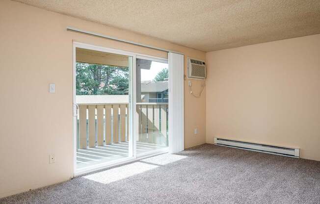 A room with a sliding glass door leading to a balcony.