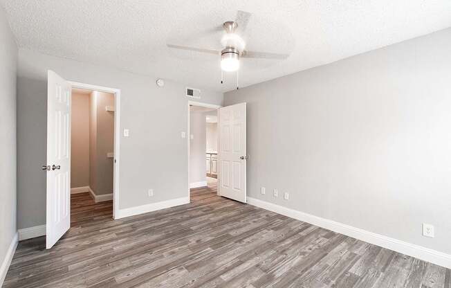 A2 upgraded apartment bedroom with ceiling fan and walk-in closet at Vine Apartments in Arlington, TX