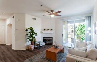 A living room with a fireplace and a ceiling fan.