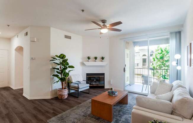 A living room with a fireplace and a ceiling fan.