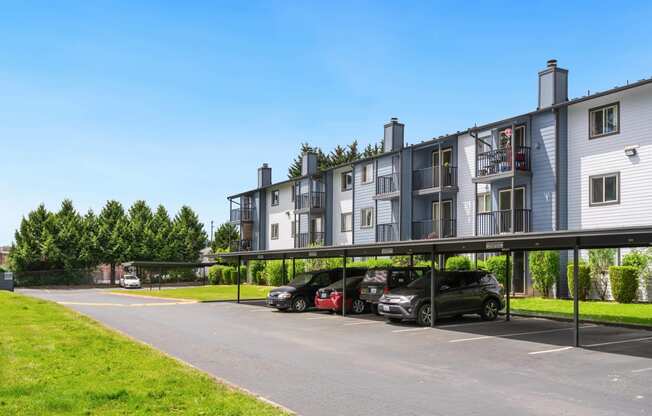 a parking lot with cars in front of an apartment building at Eagles Landing Apartments, Everett, WA 98204  