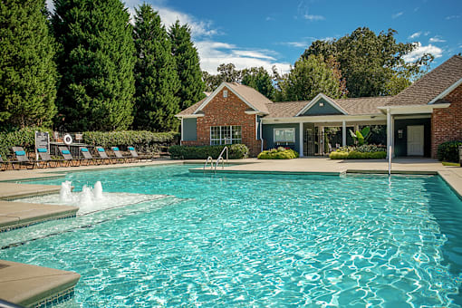 A pool with a house in the background.