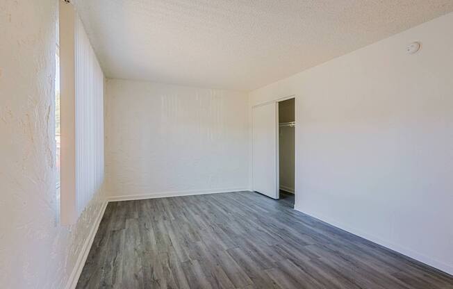 A room with wooden flooring and white walls.