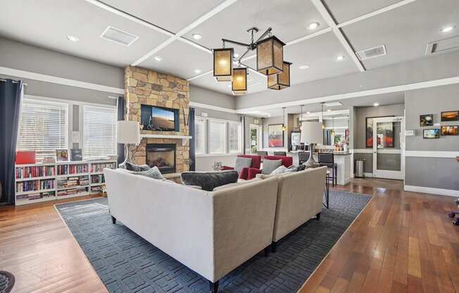 A living room with a stone fireplace and a large couch.