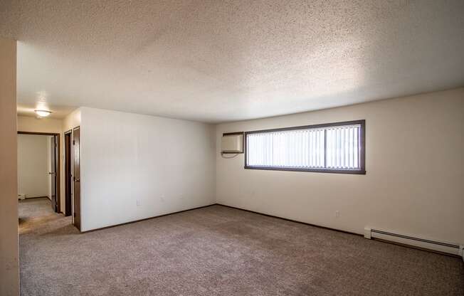 Bismarck, ND Rosser Apartments. an empty living room with a large window